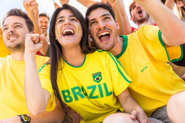 istock Brazilian supporters celebrating at stadium with flags 974713480
