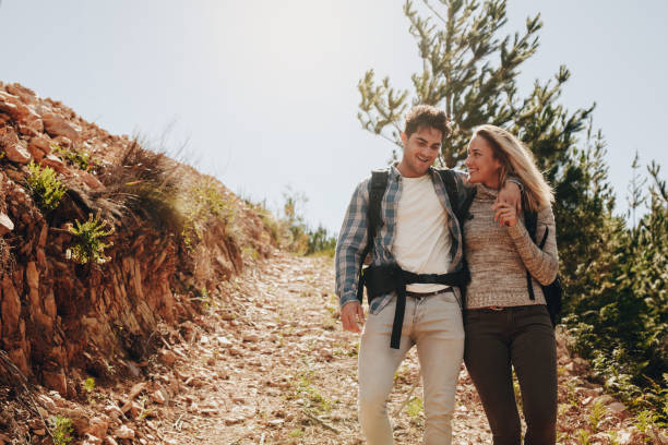 istock Couple walking down the mountain trail 974713890