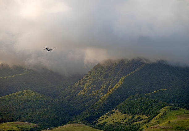 istock light aircraft flying in storm over rain forest 97471432