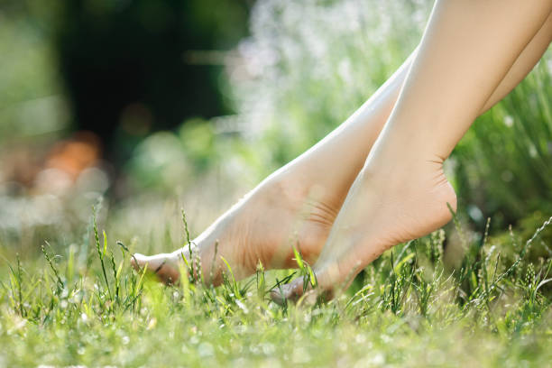 istock female legs walking on green grass 974718544