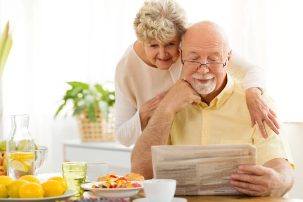 istock Senior couple reading newspaper during morning breakfast 974718758
