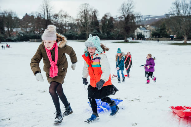 istock Friends Sledding on a Hill 974718770