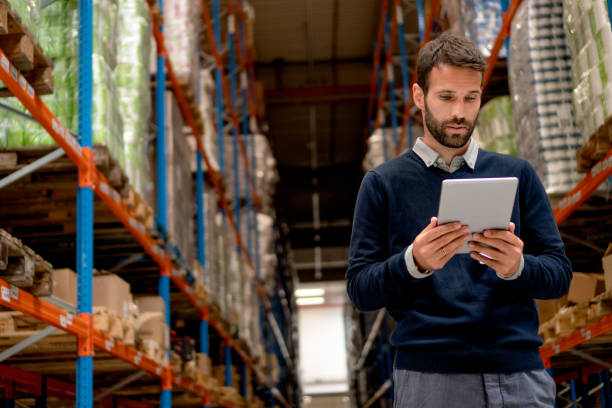 Manager in possesso di tablet digitale in magazzino - foto stock