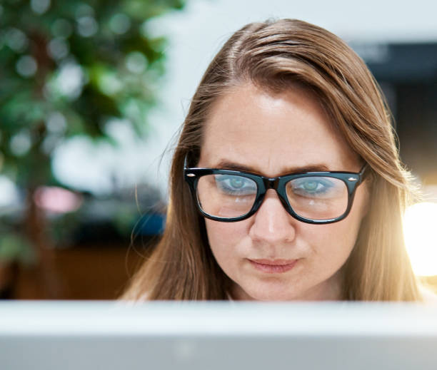 istock Blonde office worker frowns in frustration at her computer 974722162