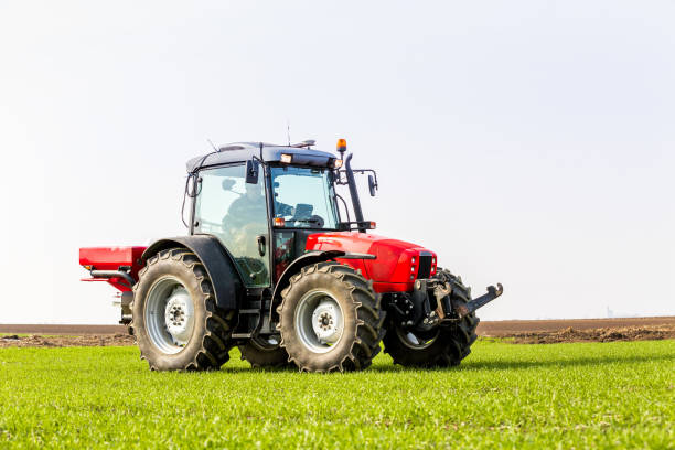 istock Farmer in tractor fertilizing wheat field at spring with npk 974722364