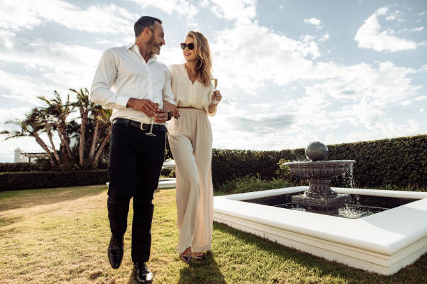 couple élégant, marcher à l’extérieur dans la pelouse - high society luxury women upper class photos et images de collection