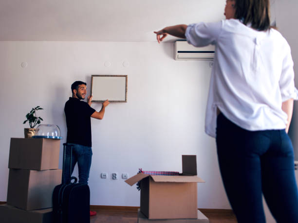 istock Couple hanging picture with frame on wall 974725058