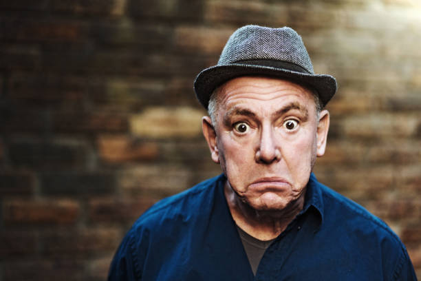 Senior man looks shocked Senior man grimaces as he stares at the camera. confused face stock pictures, royalty-free photos & images