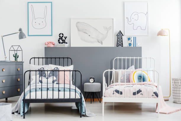 istock Simple style siblings bedroom interior with black and white beds. Rabbit, whale and elephant posters on white wall and gray drawer cabinet. Real photo 974725632