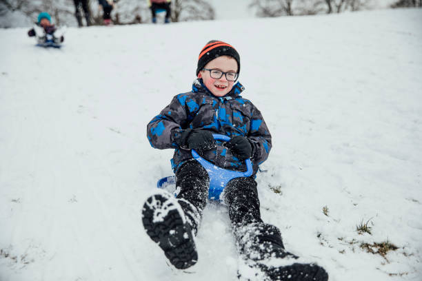 kleiner junge auf einem schlitten - little boys sled clothing slide stock-fotos und bilder