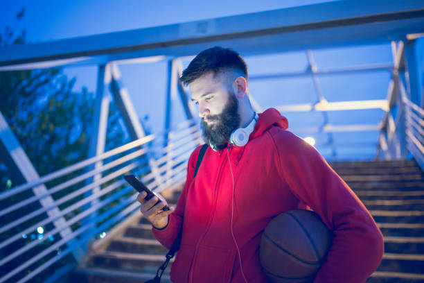 istock Sportsman using mobile phone outdoors 974738676