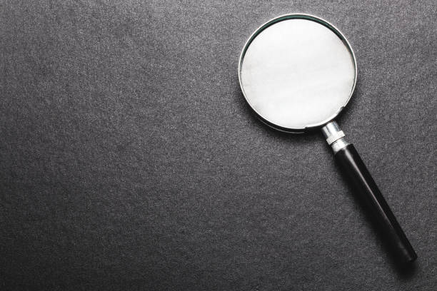 istock magnifying glass on  black texture  background. 974742538