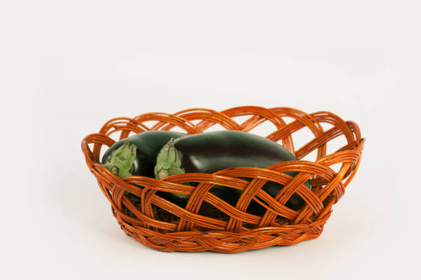 istock two ripe eggplant in a wicker basket.isolated on white 974742672