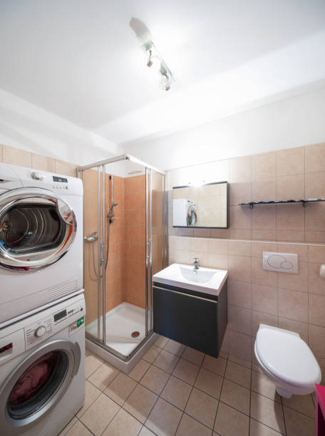 istock Modern bathroom with tile, shower, washing machine and dryer 974745466