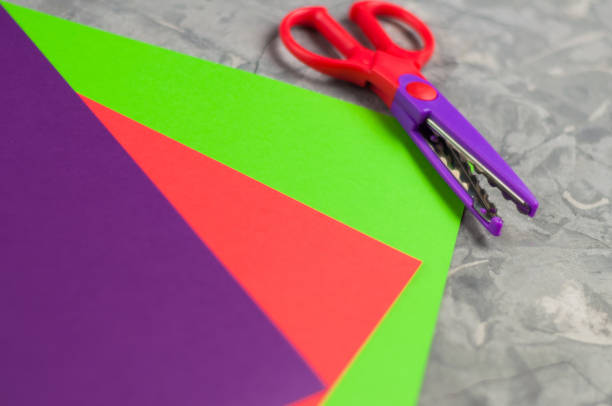 istock Scissors for figured cutting near blank colored papers on old concrete surface. Education concept 974746066