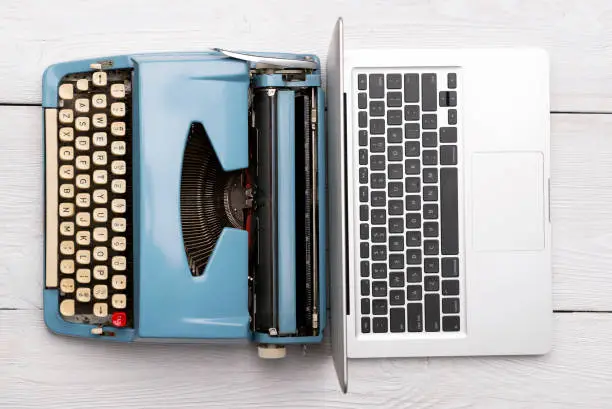 Photo of Classic analog typewriter vs Modern digital hi-tech laptop computer