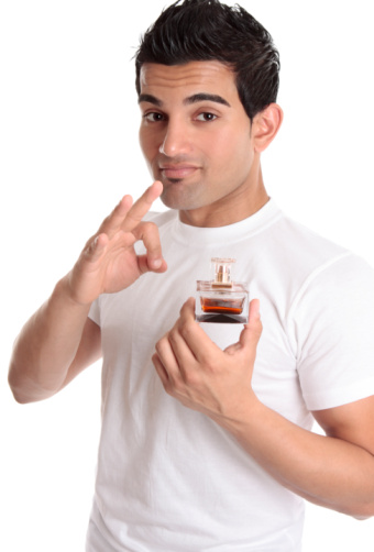 Bottle of perfume surrounded by different spices on white background, top view