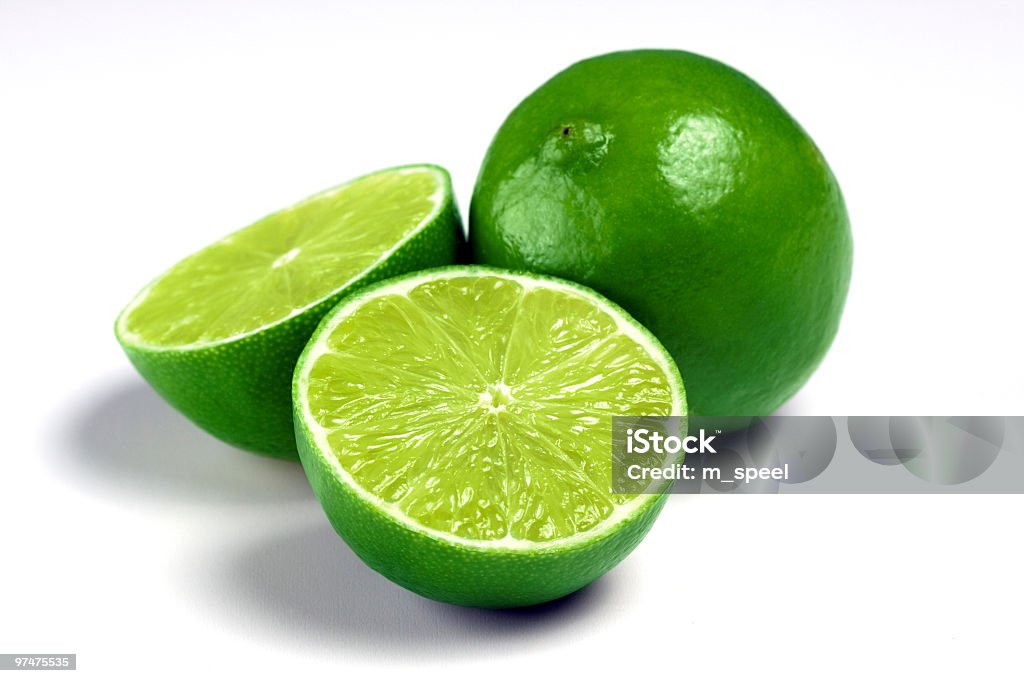 One whole lime and two lime halves on a white background Lime isolated white background Citrus Fruit Stock Photo