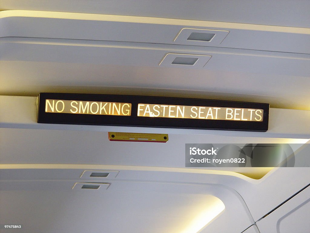 Airplane Sign - No Smoking/Fasten Seat Belts a lighted No Smoking and Fasten Seat Belt sign inside an aircraft Adrián Fernández - Race Car Driver Stock Photo