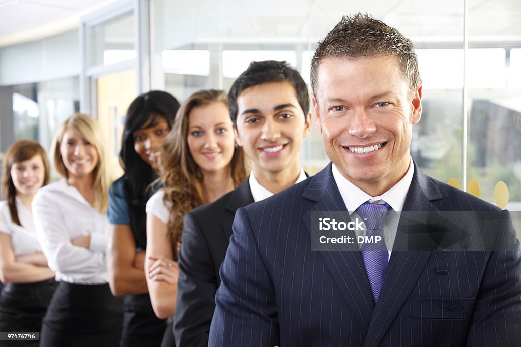 Bem sucedido homem Executive com os colegas no fundo - Foto de stock de Envolvimento dos funcionários royalty-free