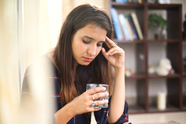 istock Sick woman drinking water 974785858