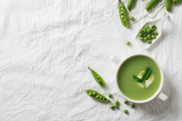 sopa de ervilhas em tigela com corpos de ervilha e creme - pea and mint soup - fotografias e filmes do acervo