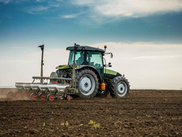 istock Farmer seeding, sowing crops at field. 974786230