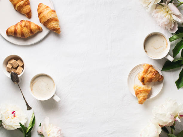 Croissants with cup of coffee and flowers