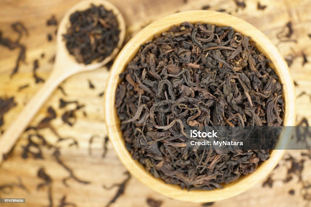 Tea leaves on wood background Tea leaves in bowl on wood background Aromatherapy Stock Photo