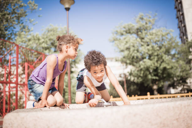 Cute mixed race children playing outdoors in public park