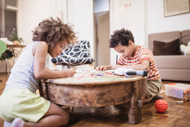 istock Cute mixed - race siblings playing and drawing at home 974795062