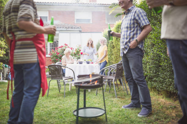 istock Mature male friends having beer while barbecuing at backyard 974806994