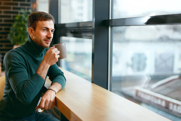 istock Man Drinking Coffee Drink In Cafe Near Window 974812480