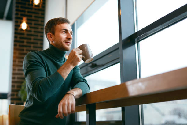 istock Man Drinking Coffee Drink In Cafe Near Window 974812562
