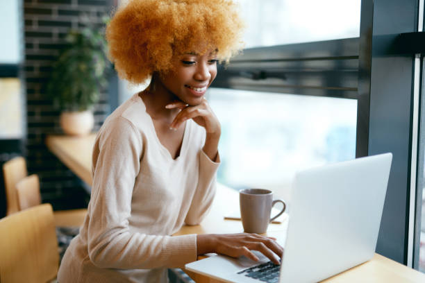 istock Beautiful Woman Working On Notebook In Cafe 974812982