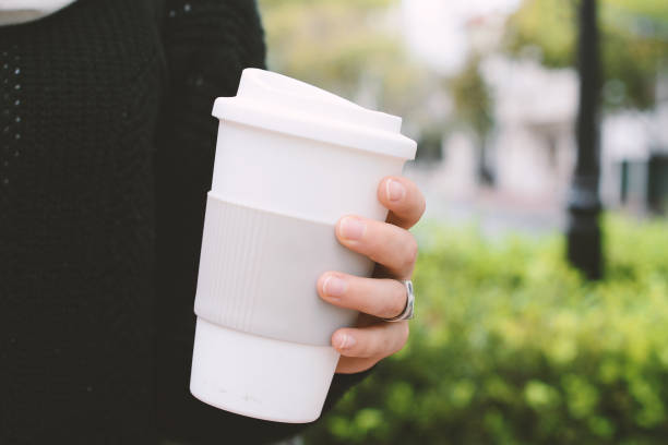 istock Close up view of hand holding plastic cup with sleeve 974813002