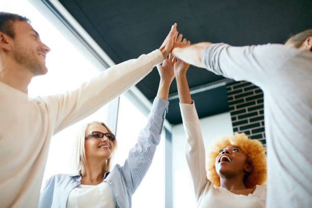 istock Teamwork. Smiling People Putting Hands Together 974820560