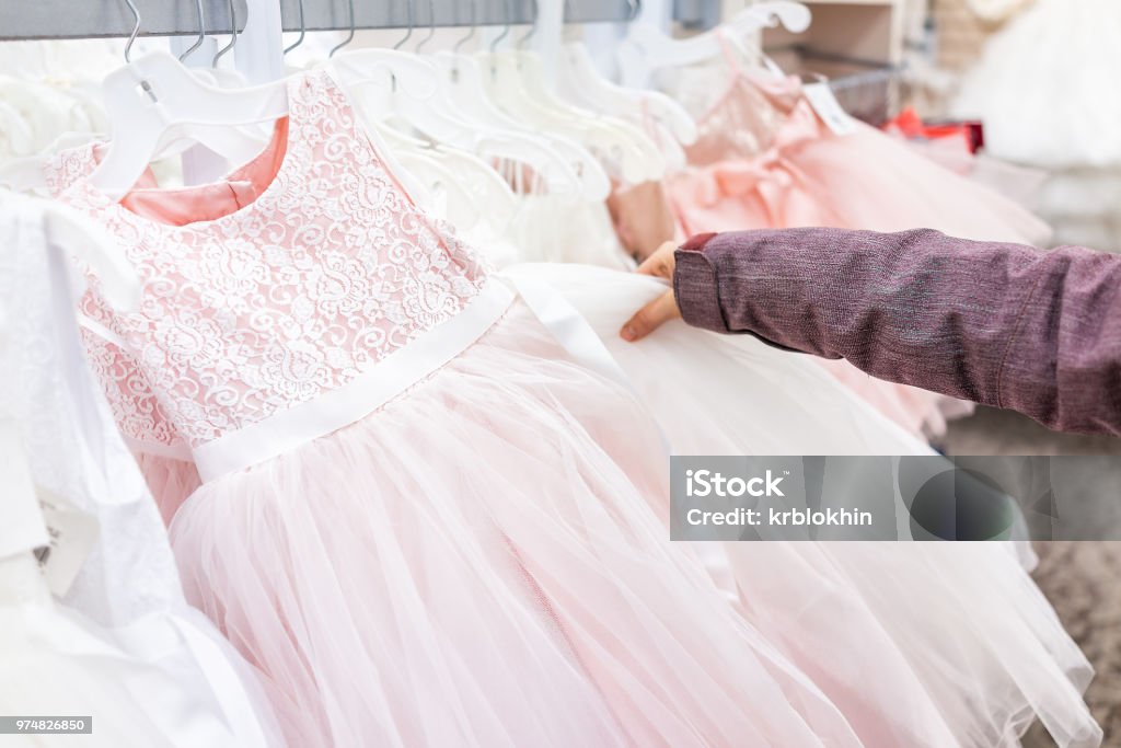 Joven Tocando Una Boda Vestido De Fiesta De Niña De Las Flores En Tienda De Descuento Boutique Rosa Colgando De Rack Closeup De Fila De Perchas Con Encaje Blanco Tul Diseño De Joven Tocando Una Boda Vestido De Fiesta De Niña De Las Flores En Tienda De Descuento Boutique Rosa Colgando De Rack Closeup De Fila De Perchas Con Encaje Blanco Tul Diseño De