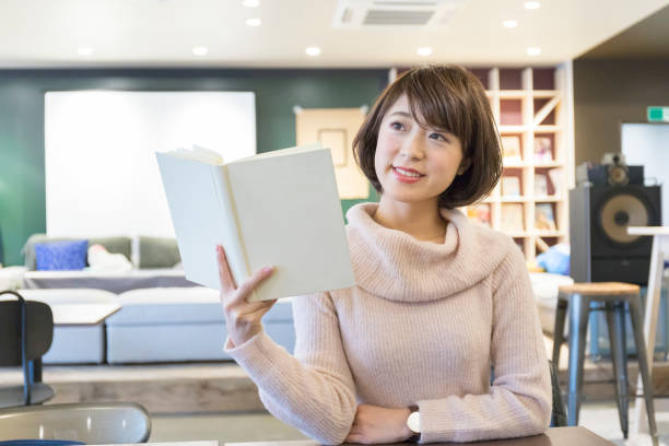 istock A woman reading a book at a cafe 974827940