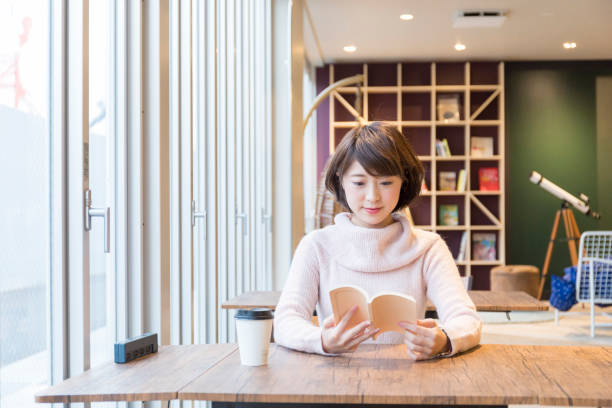 istock A woman reading a book at a cafe 974828120
