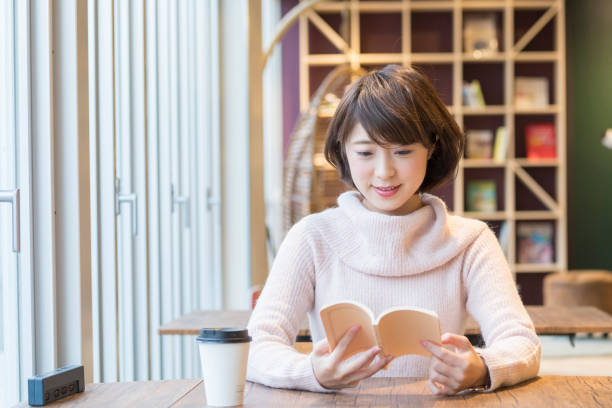 istock A woman reading a book at a cafe 974828122