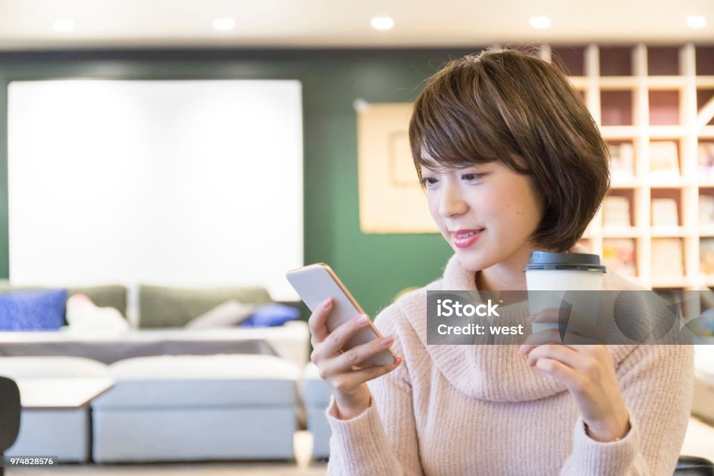 A woman relaxing at a cafe Smart Phone Stock Photo
