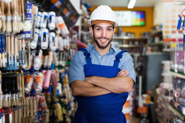 istock Confident handyman with folded arms in paint store 974849138