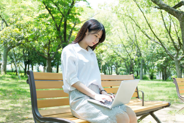 istock A woman who plays a personal computer at a park 974853290