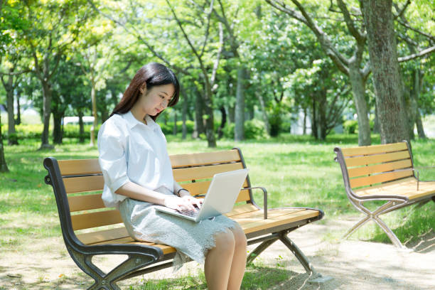 istock A woman who plays a personal computer at a park 974853300