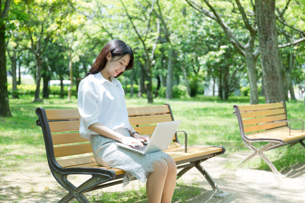 istock A woman who plays a personal computer at a park 974853308