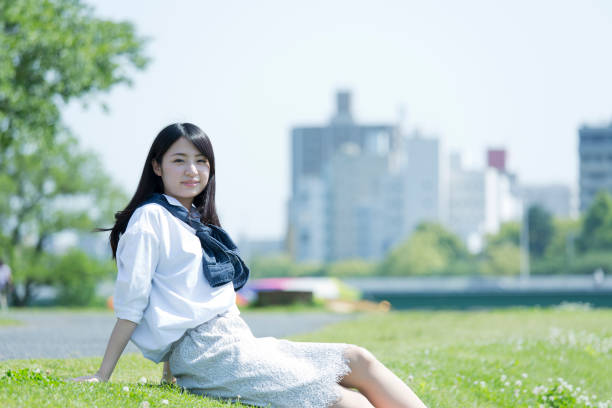A woman taking a break along a riverA woman sitting on the grass and taking a break