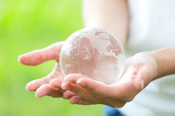 istock Women's hand with transparent globe 974856168