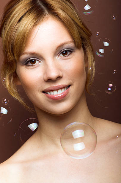 smiling woman with soap bubbles stock photo