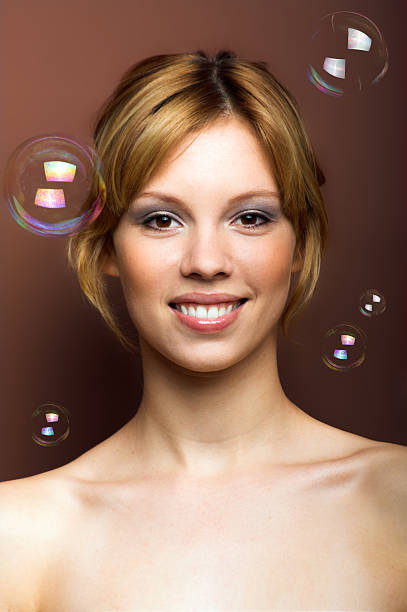 smiling woman with soap bubbles stock photo